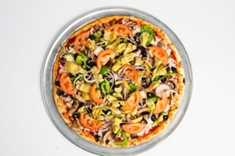 A whole vegetarian pizza with tomatoes, olives, peppers, onions, and artichoke hearts.